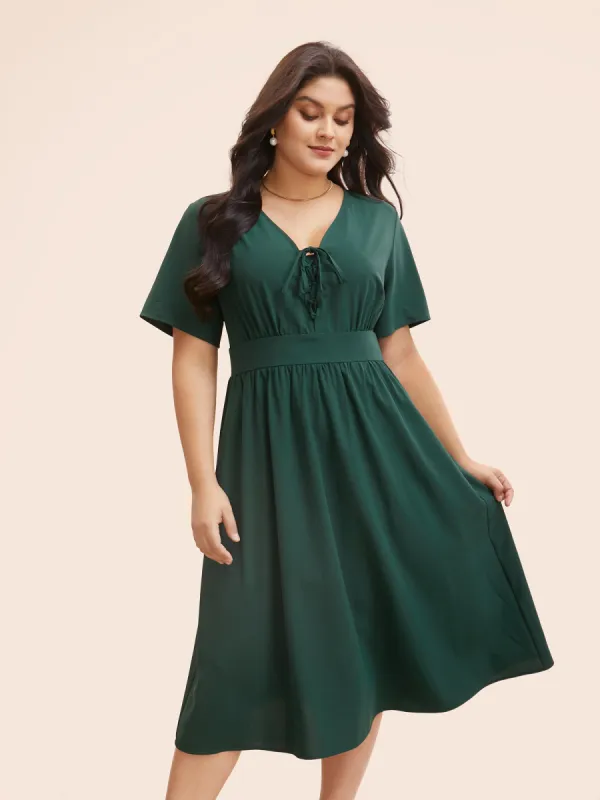 Solid V Neck Lace Up Shirred Dress sold by Bloomchic