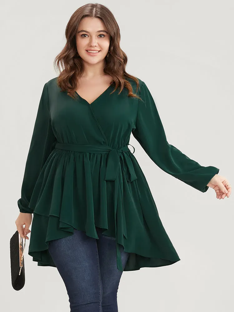 Solid Surplice Neck Belted Asymmetrical Hem Blouse sold by Bloomchic