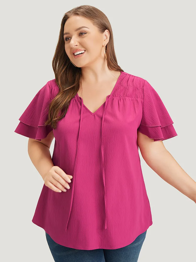 Solid Tie Neck Shirred Flutter Layered Sleeve Blouse sold by Bloomchic