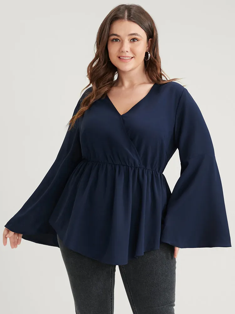 Solid Bell Sleeve Asymmetrical Hem Wrap Blouse sold by Bloomchic
