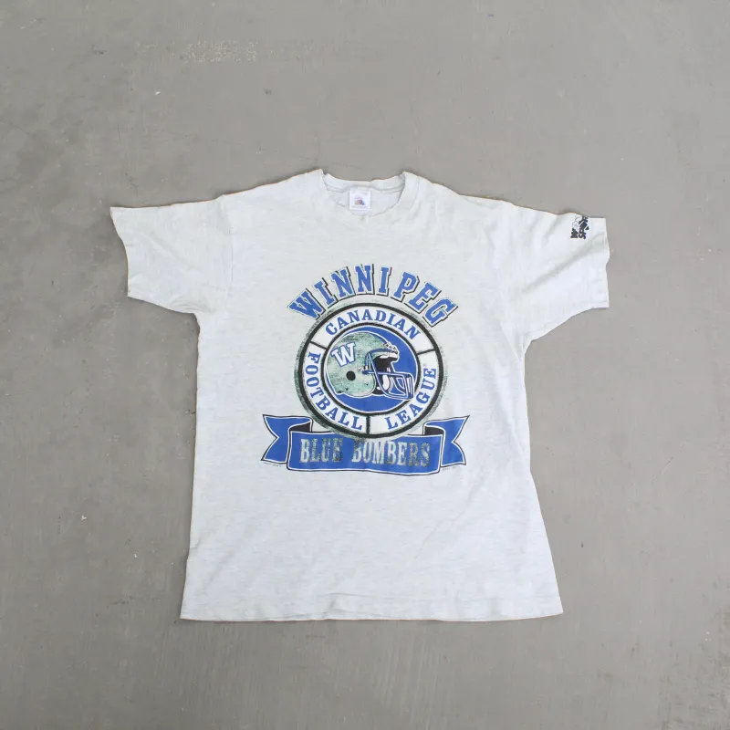 F- Vintage 1991 Winnipeg Blue Bombers CFL Text & Football Helmet Single Stitch Tee sold by HG Vintage