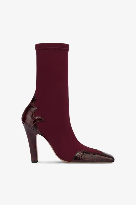 Boots in burgundy croco-embossed and stretchy leather sold by Paris Texas