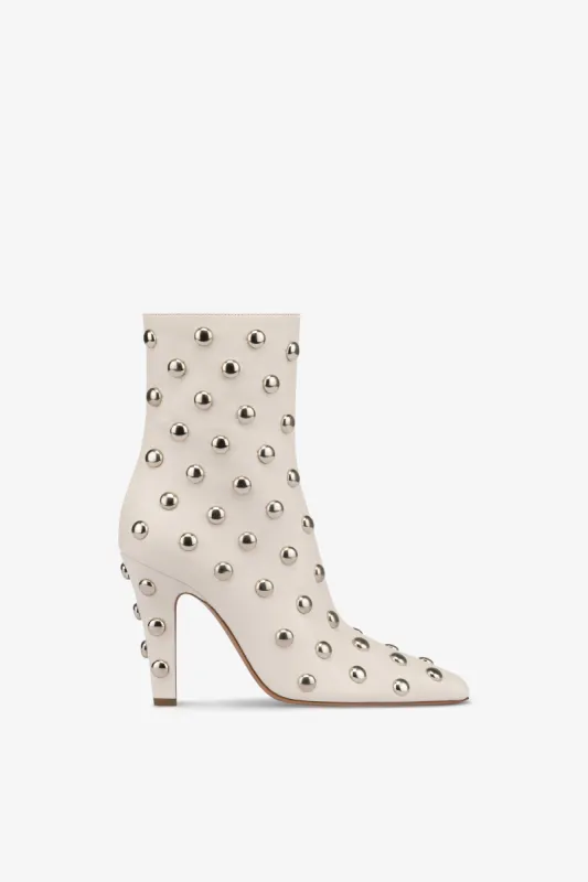 Boots in nickel-studded milk white leather sold by Paris Texas