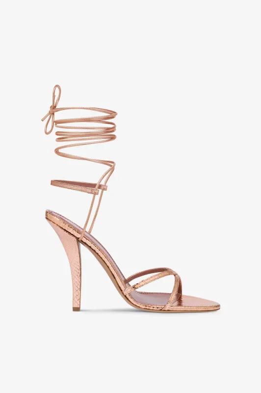Lace-up sandals in rose gold metallic python-print leather sold by Paris Texas