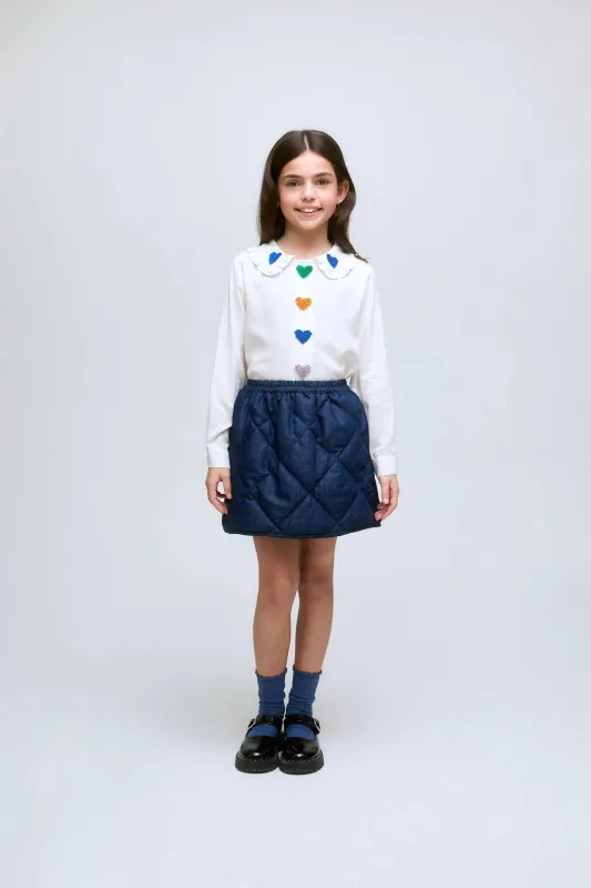 Falda corta de niña en denim acolchado con cintura elástica. sold by Compania Fantasica