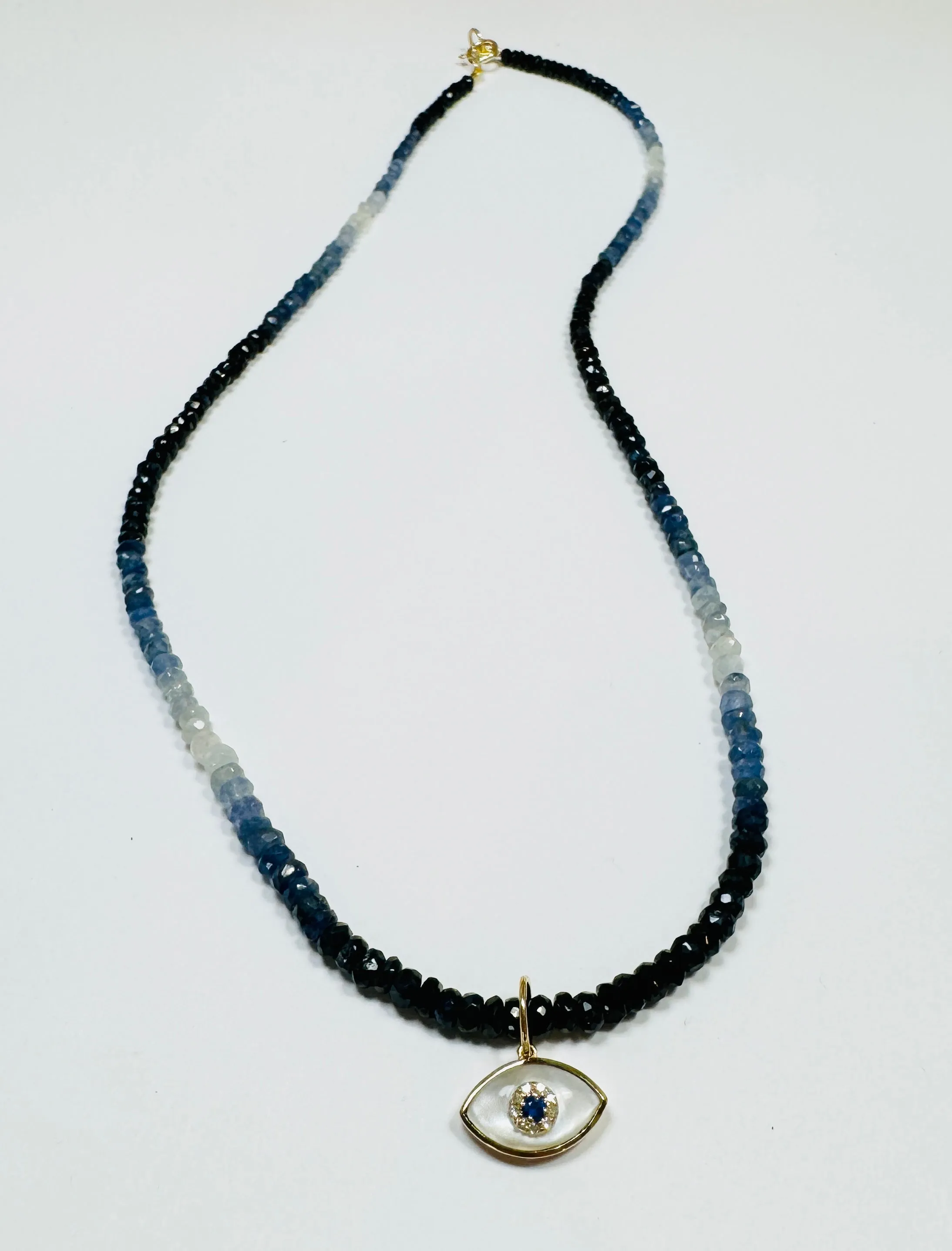 shaded blue sapphire necklace with evil eye charm sold by Theodosia