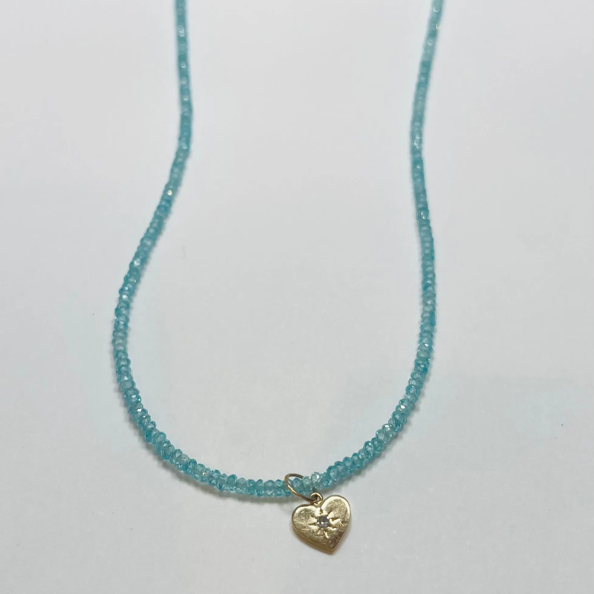 delicate blue topaz necklace with heart charm sold by Theodosia