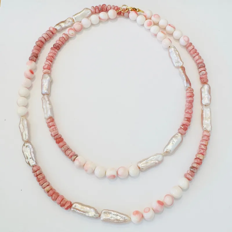 conch, pearl, and rhodochrosite layering necklace sold by Theodosia