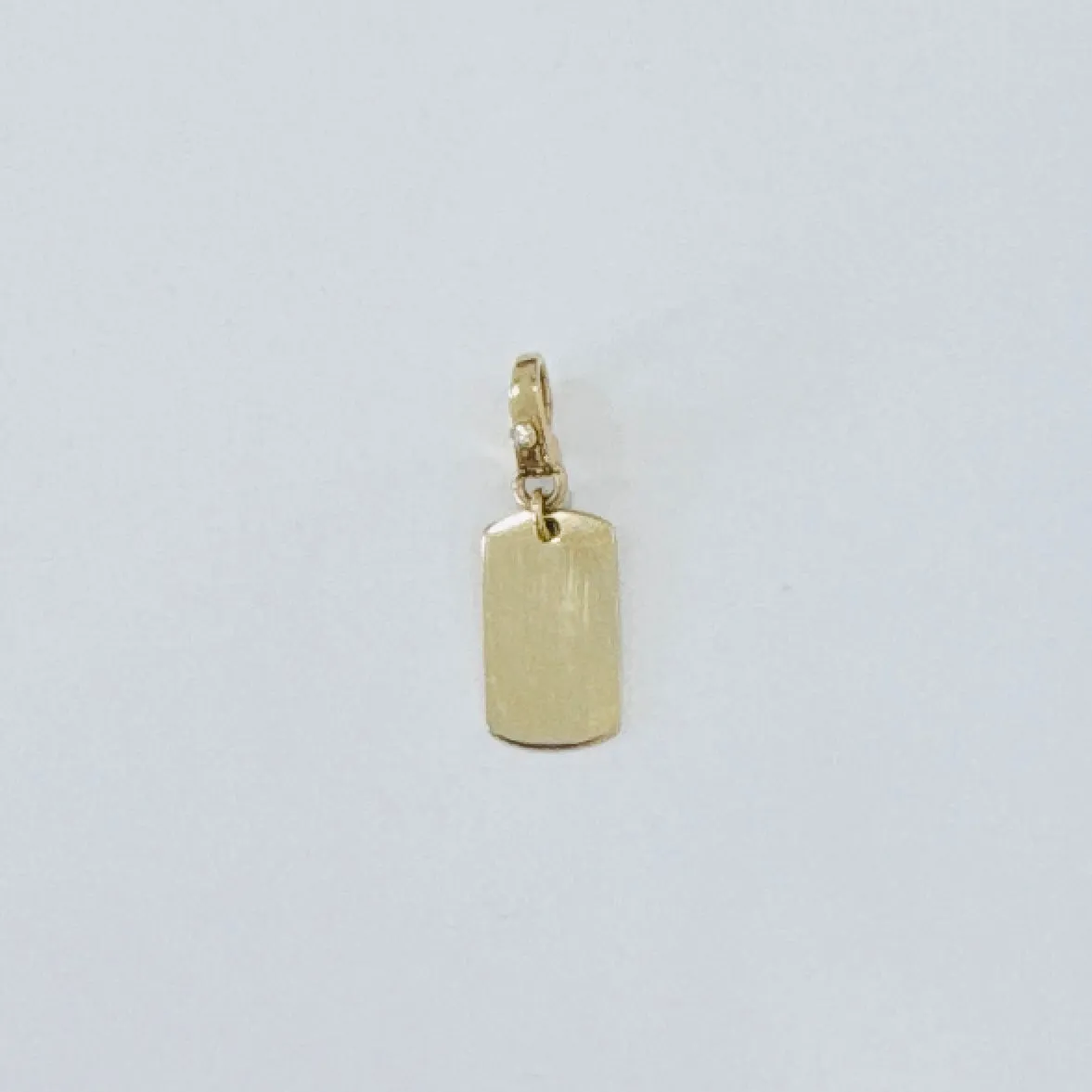 gold dog tag pendant sold by Theodosia