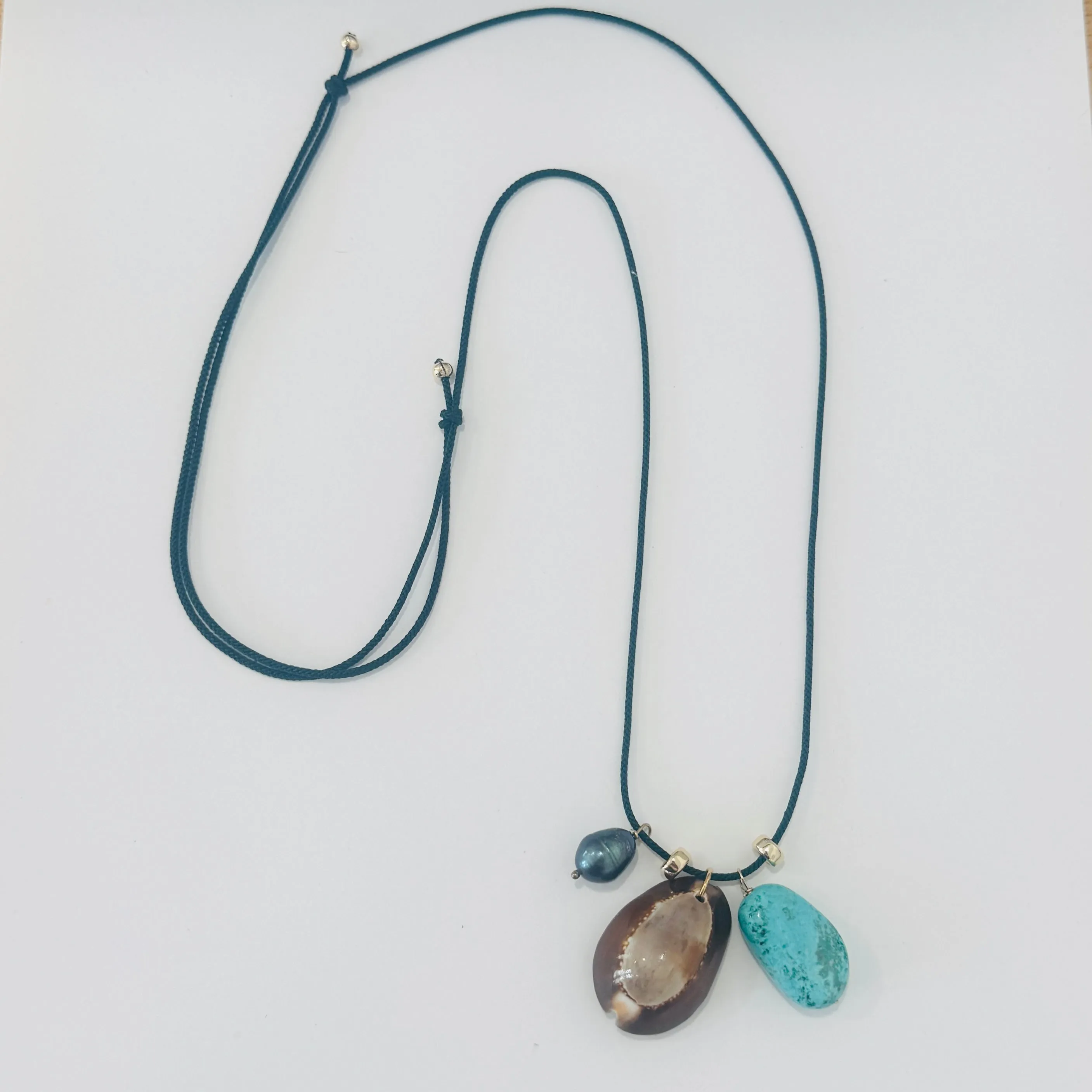 Kumihimo silk cord charm necklace, teal with turquoise, pearl, and cowrie shell sold by Theodosia
