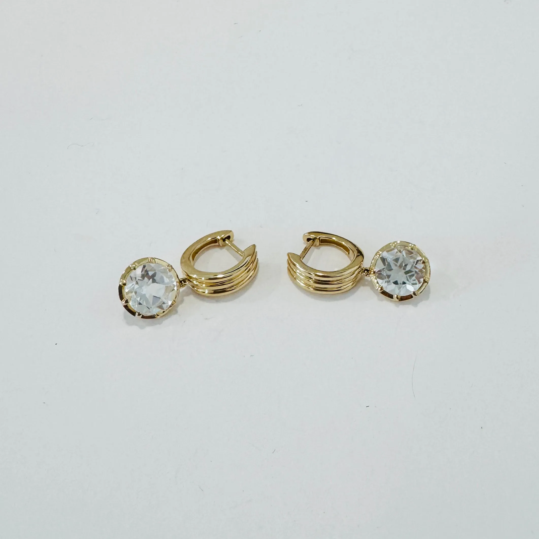 Fluted Huggies with brilliant white topaz charm sold by Theodosia