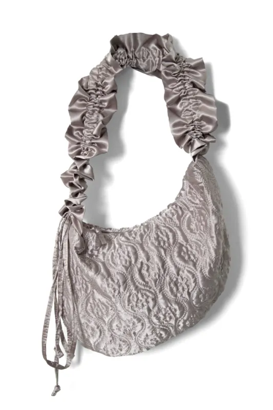 ruched kidney bag in silver satin sold by Damson Madder