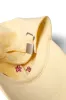 washed smiley cap in butter with red embroidery sold by Damson Madder