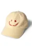 washed smiley cap in butter with red embroidery sold by Damson Madder