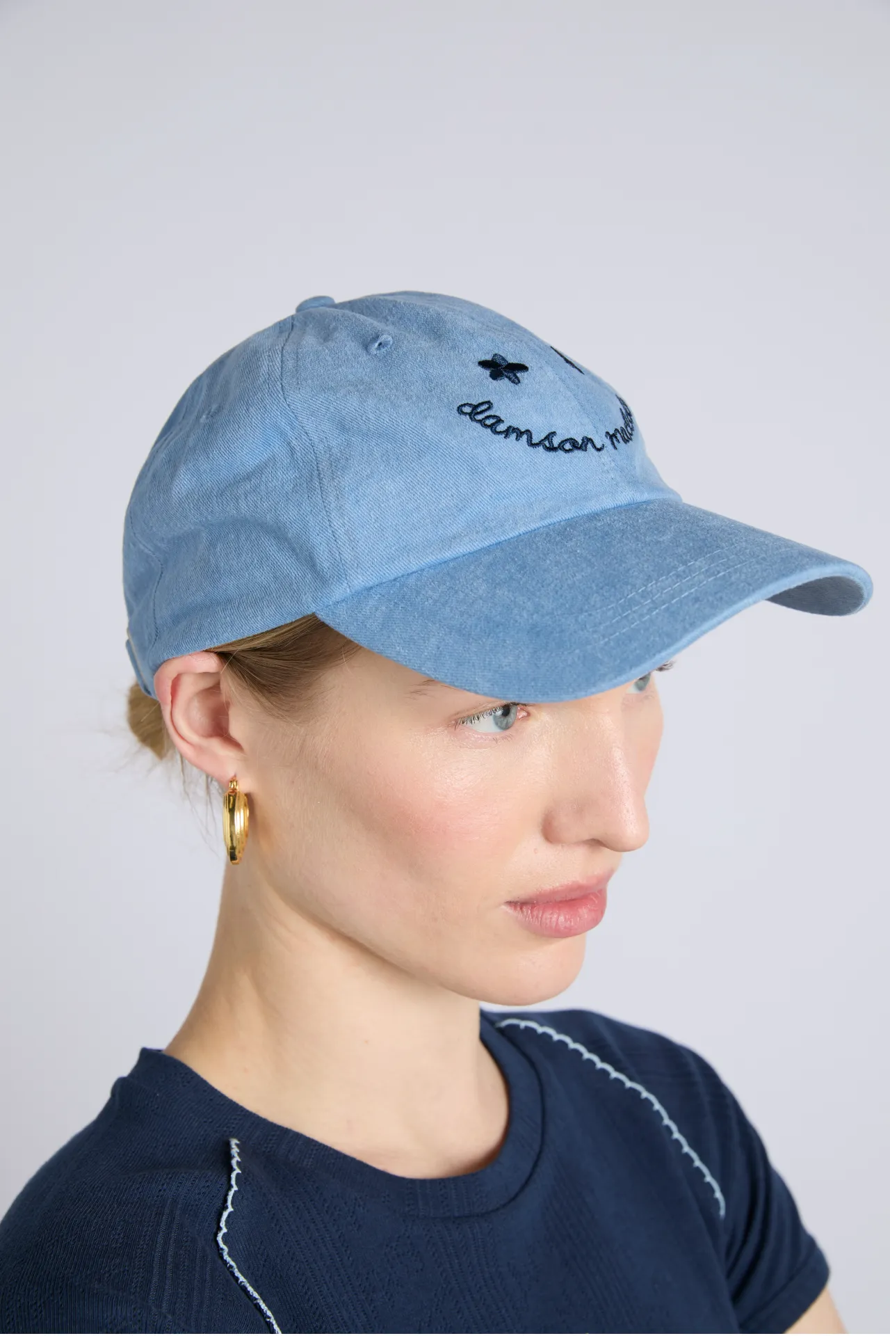 washed smiley cap in blue with navy embroidery sold by Damson Madder