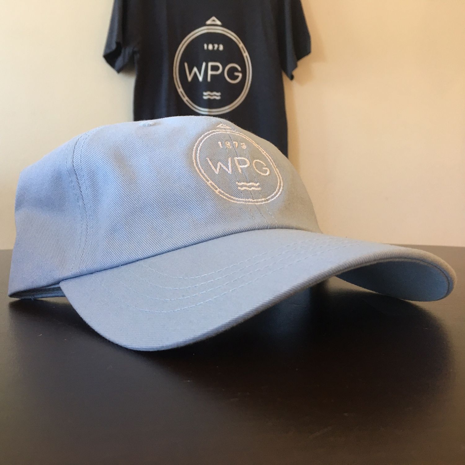 WPG Compass Dad Hat | White on Powder Blue sold by We Heart Winnipeg